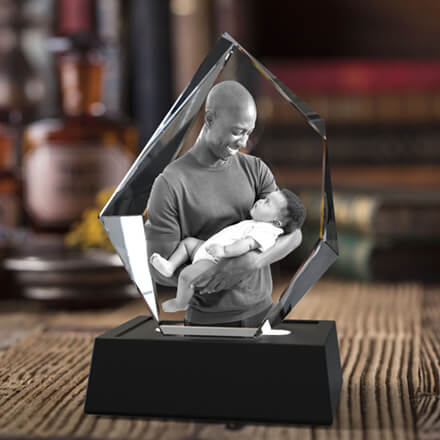 Ein Bild eines Vaters, der sein Baby hält, ist per Laser in einen 3D-Fotokristall-Eisberg eingraviert