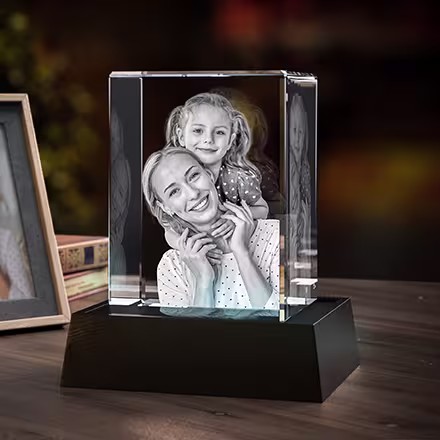 Personalisierter hoher rechteckiger 3D-Fotokristall mit einem lebensecht lasergravierten Porträt einer Mutter und ihrer Tochter, präsentiert auf einem LED-Lichtsockel.